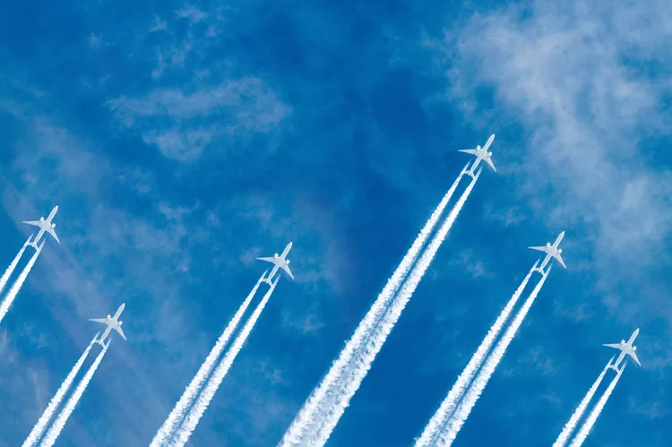 Aircraft crossing a blue sky with contrails